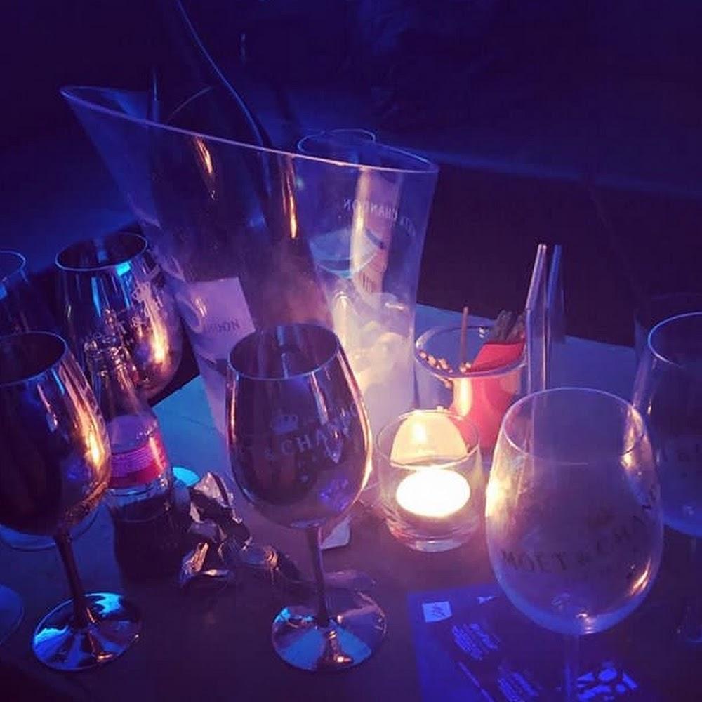 Wine glasses and a bottle on a table with a candle.